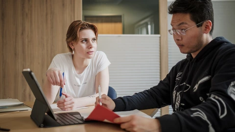 Zwei Schüler vor einem Laptop im Gespräch