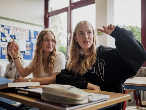 Zwei Schülerinnen in einem Klassenzimmer beim Unterricht