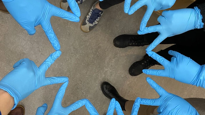 Hände von Kindern, die Handschuhe tragen und einen Stern bilden.